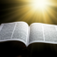 Bíblia aberta com luz brilhando, representando a abundância do Evangelho