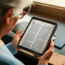 Pessoa lendo Bíblia em Tablet com fundo desfocado de outros dispositivos